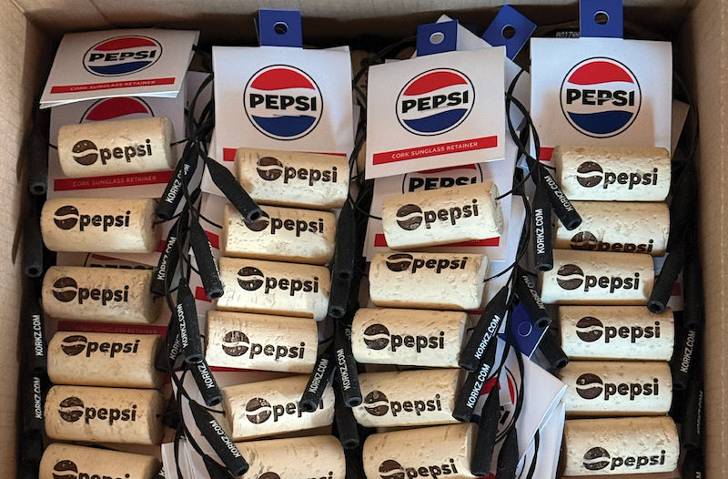Photograph of custom engraved wine cork sunglasses straps, KORKZ, ready to ship to Pepsi Bottling Ventures to be used as giveaways for their clients.