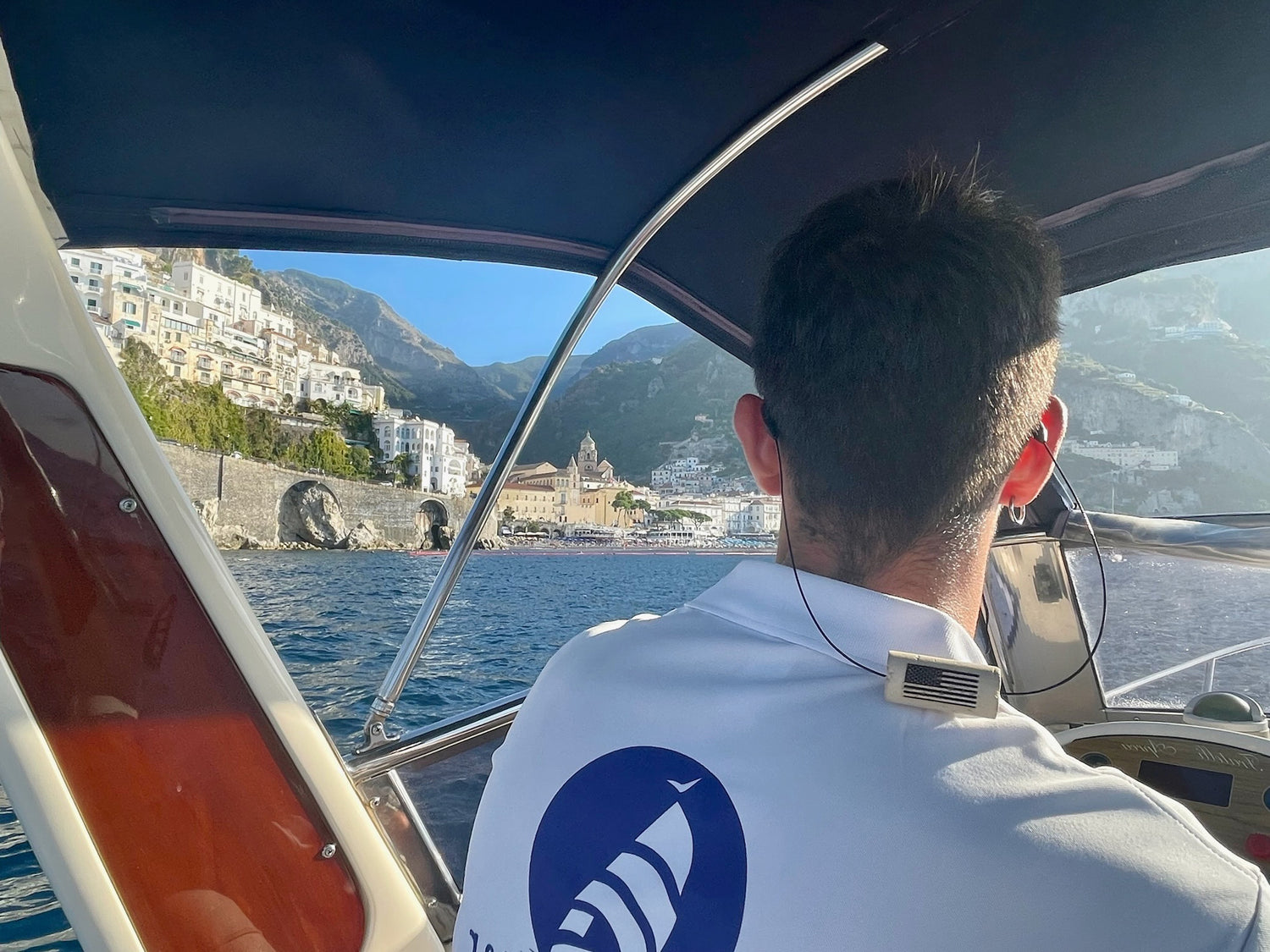 Person wearing KORKZ custom wine cork sunglass strap on a boat approaching the Amalfi Coast Italy